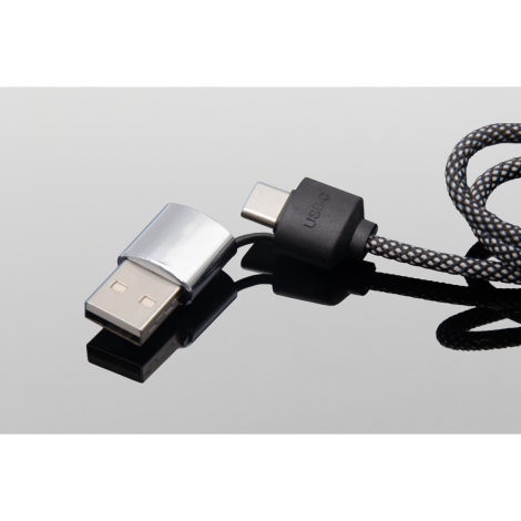 Gros plan sur un connecteur USB argenté relié au câble tressé noir.