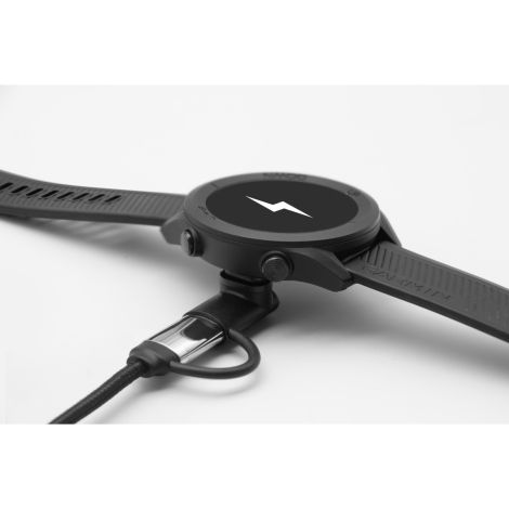 Gros plan d’un connecteur inséré dans une montre Garmin noire posée à plat.