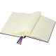 Carnet A5 ouvert sur pages crème imprimées avec colonnes et rubans colorés visibles.