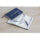 Ensemble carnet bleu marine et stylo roller assorti, carnet ouvert sur pages lignées, marquage visible sur le corps et le boucho