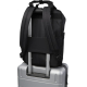 Vue arrière d’un sac noir fixé sur la poignée télescopique d’une valise grâce à une sangle horizontale.