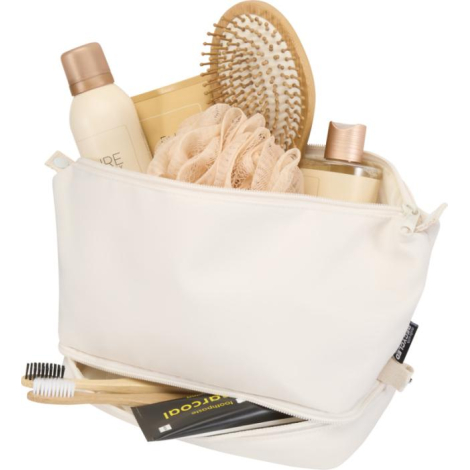 Trousse de toilette beige ouverte contenant des produits de soin et accessoires visibles.