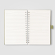Vue intérieure du carnet montrant la spirale et les pages lignées. Vue intérieure du carnet montrant la spirale et les pages lignées.