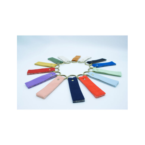 Série de porte-clés multicolores disposés en cercle sur fond clair, anneaux dorés au centre