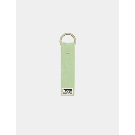 Porte-clés vert d’eau avec anneau doré et rivet central, marquage en bas.