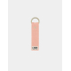 Porte-clés rose saumon avec anneau doré et rivet central, marquage en bas. Porte-clés rose saumon avec anneau doré et rivet central, marquage en bas.