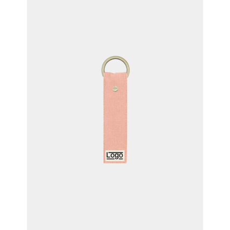Porte-clés rose saumon avec anneau doré et rivet central, marquage en bas.