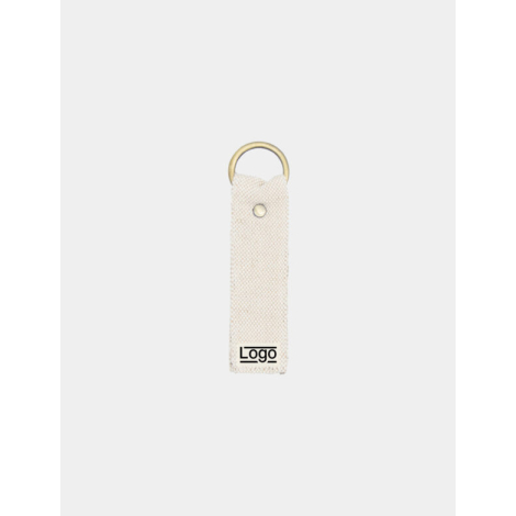 Porte-clés écru texturé avec anneau doré et rivet central, marquage en bas.