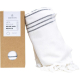 Fouta blanche roulée accompagnée de son coffret cadeau cartonné avec ouverture circulaire laissant entrevoir le textile ; sans m