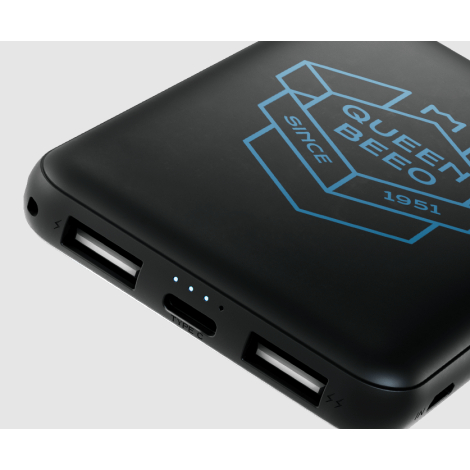 Powerbank noire en plastique recyclé en gros plan, affichant les ports USB, voyants lumineux et un marquage visible sur la face 