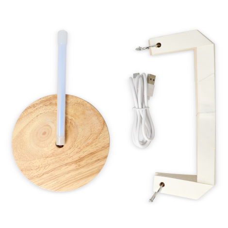 Éléments démontés : socle bois clair avec tige lumineuse, structure en papier pliable et câble USB blanc.