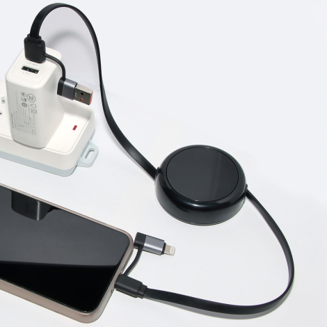 Câble rétractable noir branché à une multiprise et à un smartphone