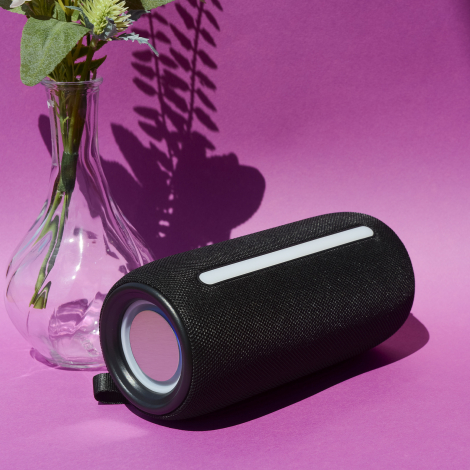 Enceinte noire sur surface violette avec bande lumineuse