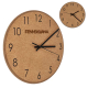 Horloge murale ronde en liège présentée en gros plan, chiffres imprimés et aiguilles noires visibles, marquage visible sur la pa