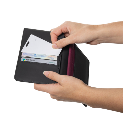 Carte de localisation blanche partiellement insérée dans un portefeuille noir ouvert tenu à deux mains, plusieurs cartes visible