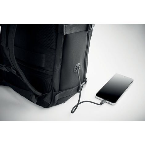Vue arrière du sac posé sur une surface claire avec câble branché à un smartphone illustrant une connexion intégrée, sans marqua
