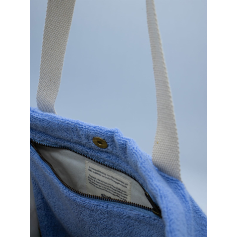 Détail du haut d’un sac de plage en éponge avec fermeture aimantée et étiquette intérieure