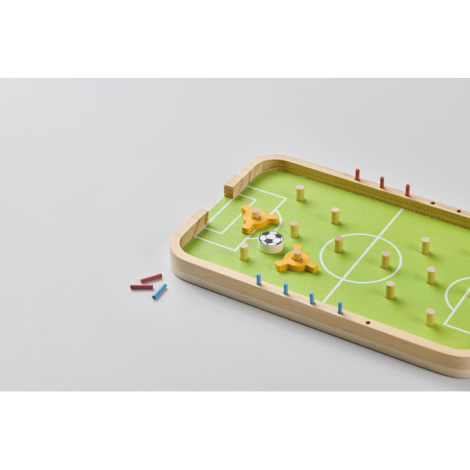Jeu de football en bois en perspective sur fond clair, plateau partiellement visible avec pièces déplacées à côté, trous de posi