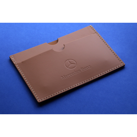 Étui carte grise rectangulaire vu de trois-quarts en cuir marron avec deux fentes visibles et personnalisation apparente sur la 