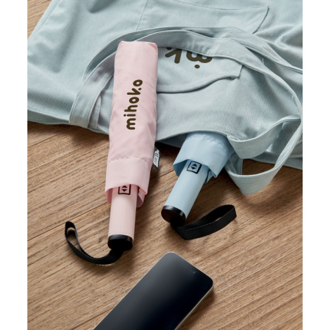 Deux parapluies pliés présentés sur un sac en tissu, l’un rose et l’autre bleu clair, rangés dans leurs housses assorties, perso