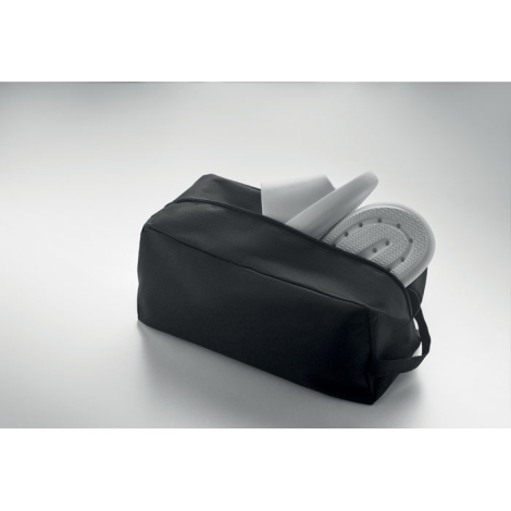 Sac à chaussures partiellement ouvert avec une paire de sandales blanches insérée à l’intérieur, sans marquage visible.