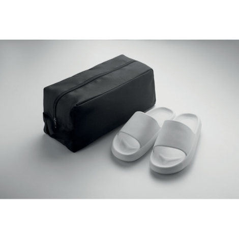 Sac à chaussures présenté à côté d’une paire de sandales blanches, fermeture fermée, sans personnalisation apparente.