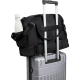Sac de sport noir fixé sur la poignée télescopique d’une valise, vue arrière avec poche latérale contenant une gourde, sans pers Sac de sport noir fixé sur la poignée télescopique d’une valise, vue arrière avec poche latérale contenant une gourde, sans pers
