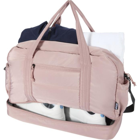 Sac de sport rose ouvert montrant le compartiment principal avec vêtements et chaussures à l’intérieur, sans marquage visible.