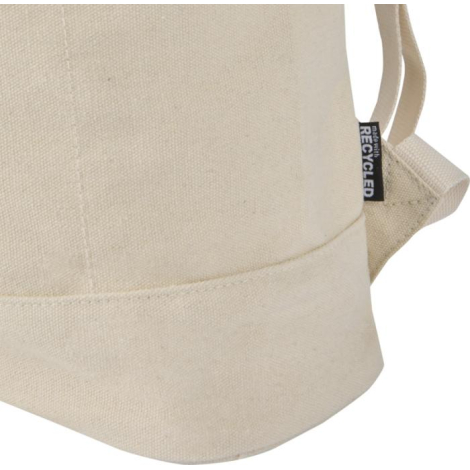 Vue rapprochée du côté d’un sac à dos rolltop beige avec étiquette latérale, sans marquage visible.
