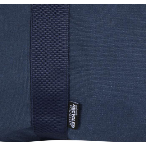 Vue rapprochée du tissu d’un sac de voyage bleu avec étiquette latérale, sans marquage visible.