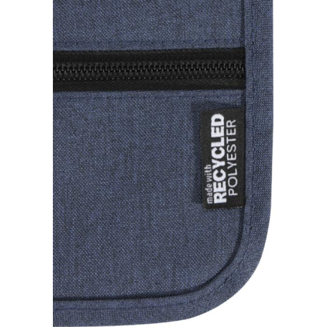 Gros plan sur la partie inférieure d’une pochette bleue, montrant la texture du tissu et une petite étiquette latérale cousue, s