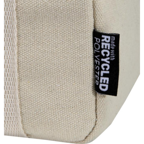 Détail de l’angle inférieur d’un sac déjeuner beige montrant la texture de la toile et une petite étiquette latérale cousue, san