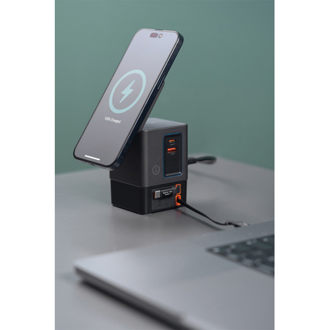 Station de charge utilisée sur un bureau avec smartphone en charge, en situation d’usage, sans marquage apparent.