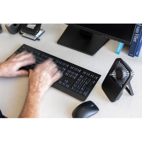 Ventilateur utilisé sur un bureau à côté d’un clavier et d’une souris, en situation d’usage, sans marquage visible.