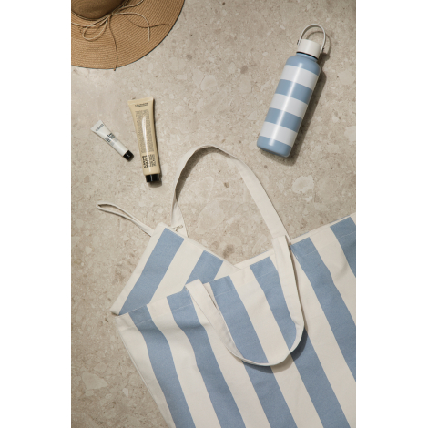 Pochette ouverte avec accessoires de toilette à proximité, présentée sur fond clair, sans personnalisation apparente.