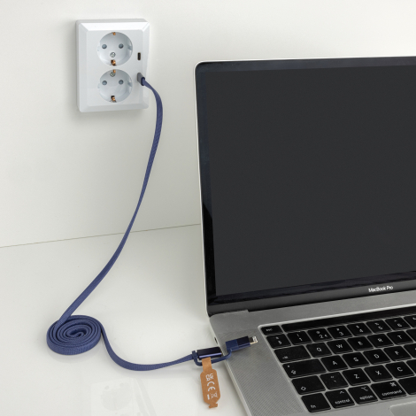 Câble branché entre une prise murale et un ordinateur portable, en situation d’utilisation, sans marquage visible.