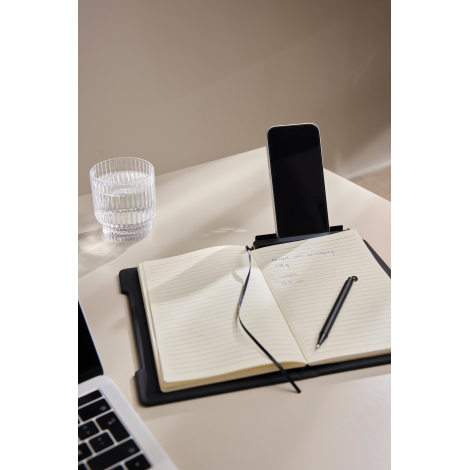 Carnet utilisé sur un bureau avec smartphone positionné en support et stylo posé sur les pages, en situation d’usage, sans marqu