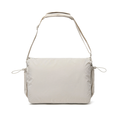 Sac messager beige présenté de dos avec surface arrière lisse, sur fond neutre, sans personnalisation apparente.