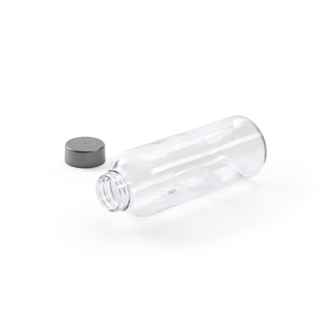 Bouteille en verre transparente couchée avec bouchon séparé à proximité, ouverture du col visible, sans marquage apparent