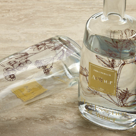 Deux bouteilles en verre avec liquide dont une couchée, présentant un marquage visible sur la surface extérieure