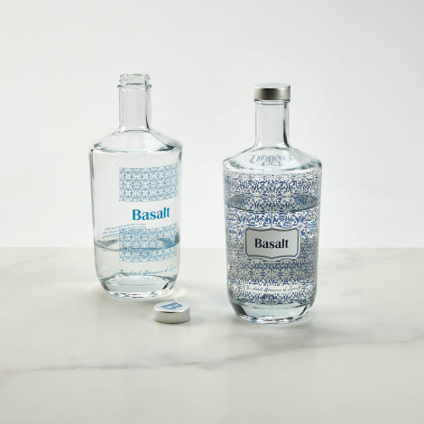 Deux bouteilles en verre contenant du liquide posées sur une surface avec marquage visible sur la surface extérieure