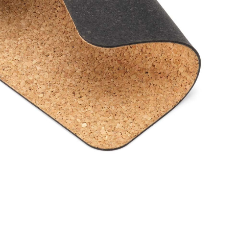Détail d’un tapis de souris en liège avec coin relevé montrant la surface en liège et le dessous foncé, sans marquage visible