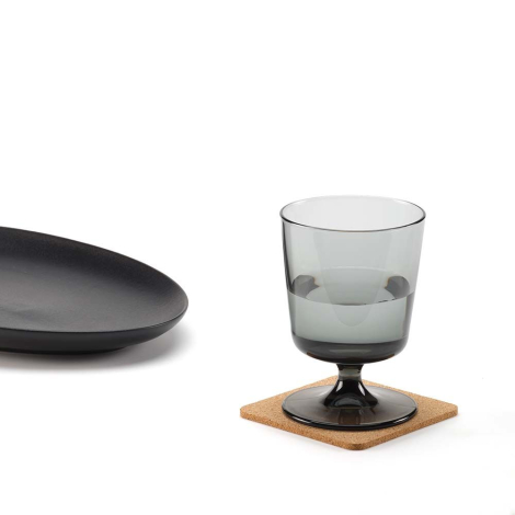 Sous-verre carré en liège utilisé sous un verre avec une assiette à proximité, sans marquage apparent