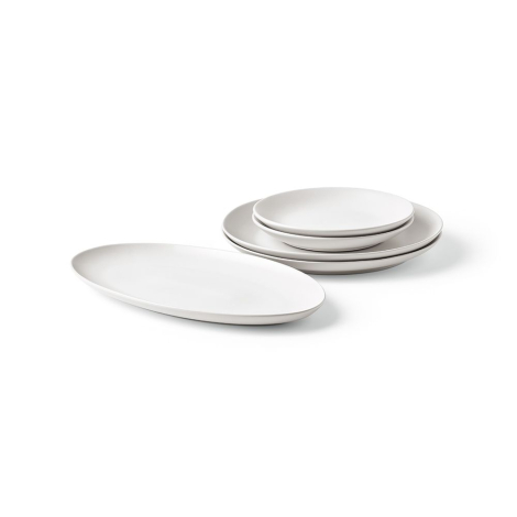 Ensemble de plats ovales en céramique blanche empilés sur une surface, sans marquage apparent
