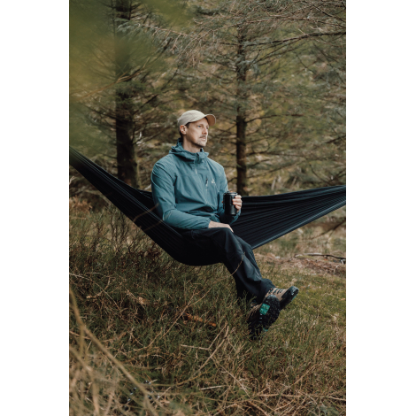 Hamac noir installé en extérieur avec personne assise, sans personnalisation apparente sur le tissu