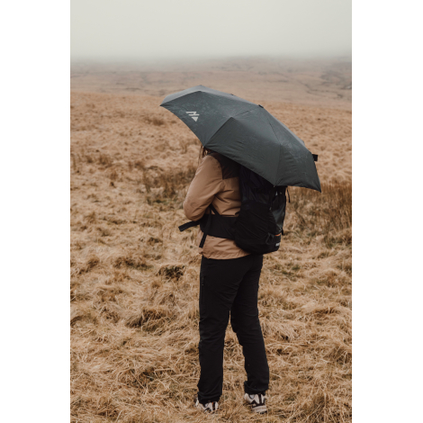 Personne de dos en extérieur tenant un parapluie ouvert, sans marquage visible sur le produit