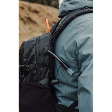 Gros plan sur côté du sac porté avec tube d’hydratation, sans personnalisation visible