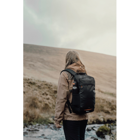 Sac à dos porté par une personne en extérieur vue de dos, sans personnalisation visible