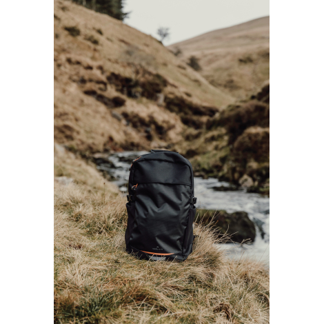 Sac à dos posé en extérieur près d’un cours d’eau, sans marquage visible