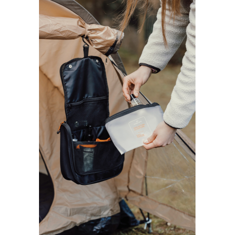 Personne manipulant une trousse ouverte en extérieur, sans personnalisation visible